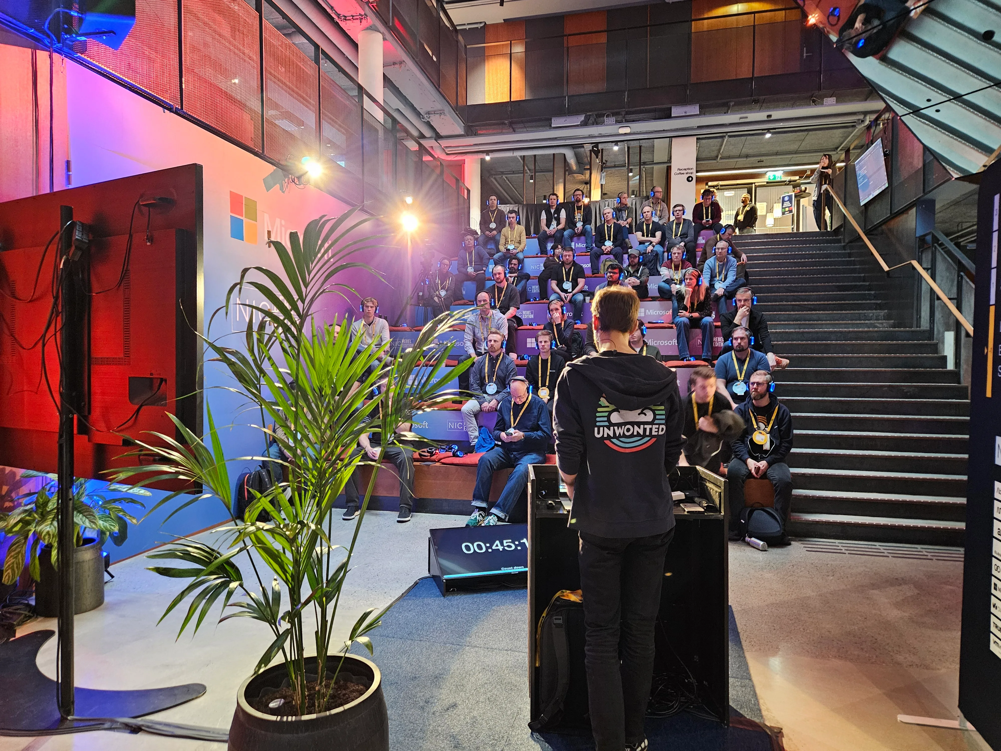 Emanuel presenting at NIC 2025 to an audience in a Microsoft conference venue.